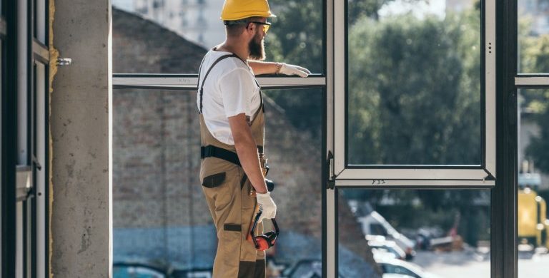 construction worker installing bulletproof window