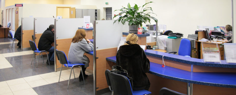 visitors in bank sitting in chairs at desk